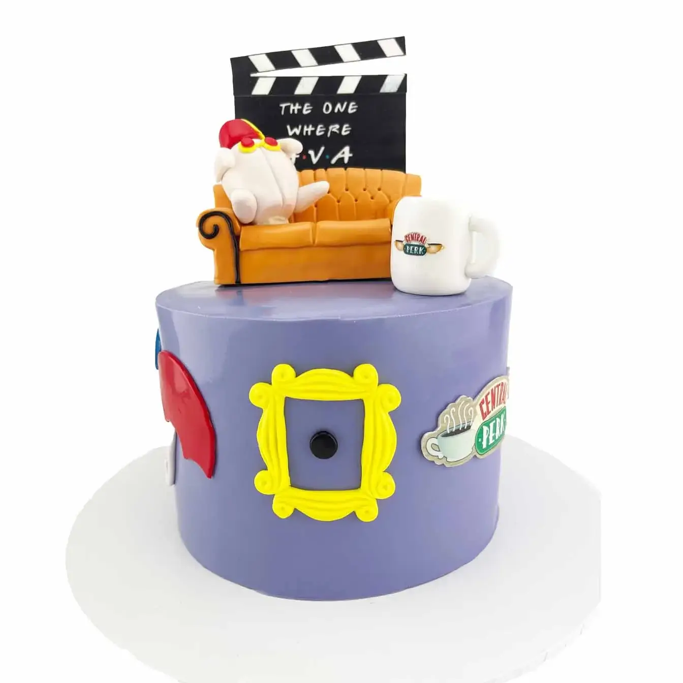 Friends-themed cake featuring a fondant replica of the iconic Friends couch, personalized clapper board, Central Perk mug, friends peep hole, and umbrellas - perfect for any celebration